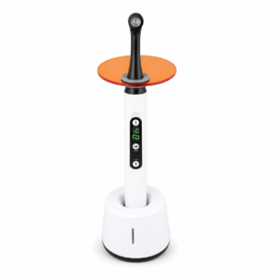 White standing appliance with a vertical control panel, green digital readout, and an orange circular top disk connected by a black stem.