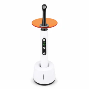 White standing appliance with a vertical control panel, green digital readout, and an orange circular top disk connected by a black stem.