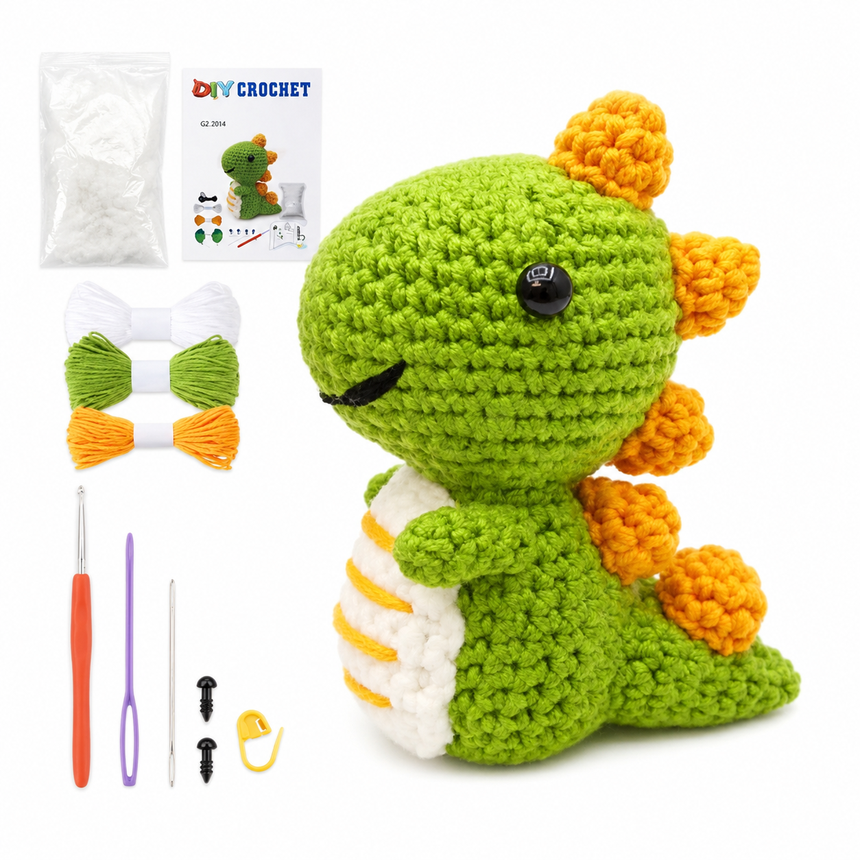 Green crocheted dinosaur amigurumi with orange spikes, part of a DIY crochet kit with yarn, hooks, and an instruction sheet.