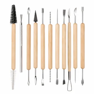 Row of wooden-handled sculpting tools with metal tips (spatulas, loops, chisels) and two brushes on the left.